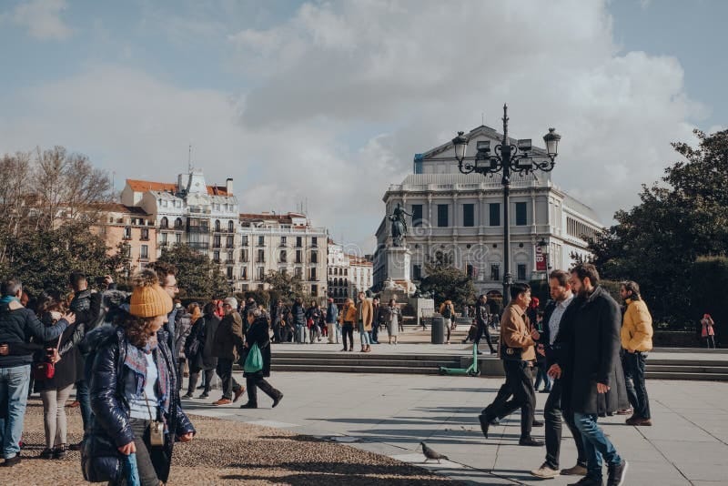 Personas de diferentes orígenes caminando por una plaza de España representando la diversidad de la sociedad española.